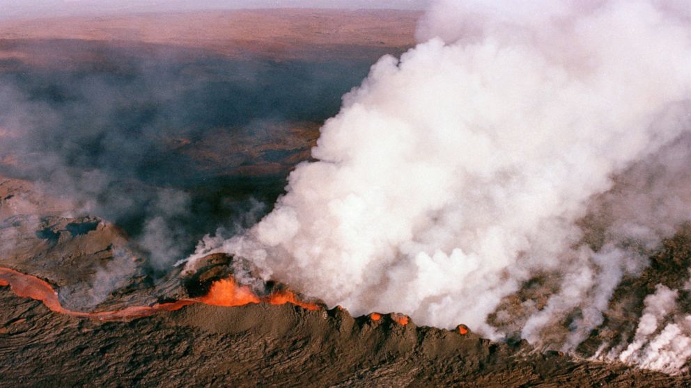 FILE - A gaseous cloud rises from the crater of Mauna Loa, center, on the big island of Hawaii, April 4, 1984. The ground is shaking and swelling at Mauna Loa, the largest active volcano in the world, indicating that it could erupt. Scientists say th