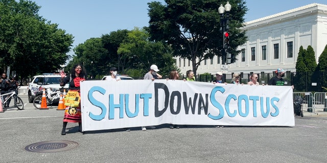 Activists hold up a sign near the Supreme Court during a protest in June.