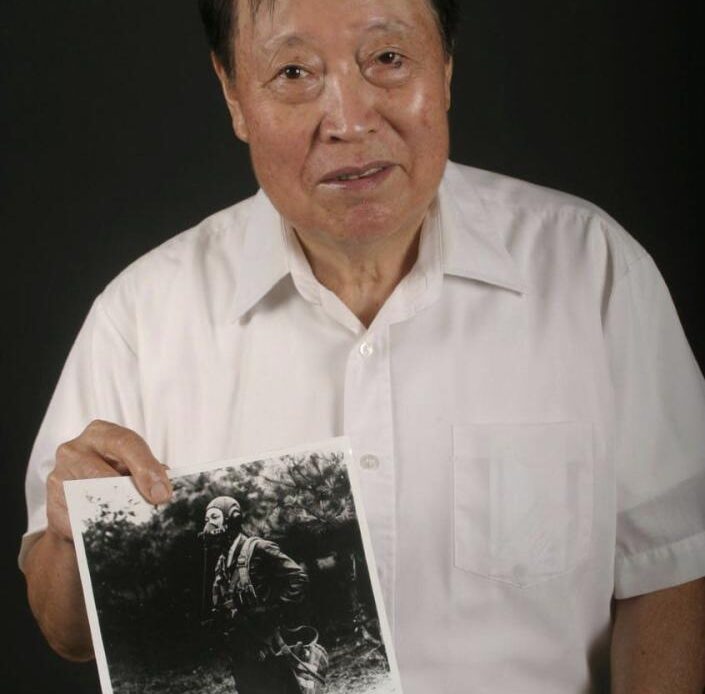 Retired Embry-Riddle Aeronautical University Professor Kenneth Rowe, seen here in 2013, holds a photo of himself when he was a fighter pilot for the North Korean Air Force during the Korean War. Rowe, at age 21, escaped from North Korea in 1953 by flying his MiG-15 fighter jet to a U.S. air base in South Korea. He died at his Daytona Beach home on Dec. 26, 2022, just a couple weeks shy of his 91st birthday.