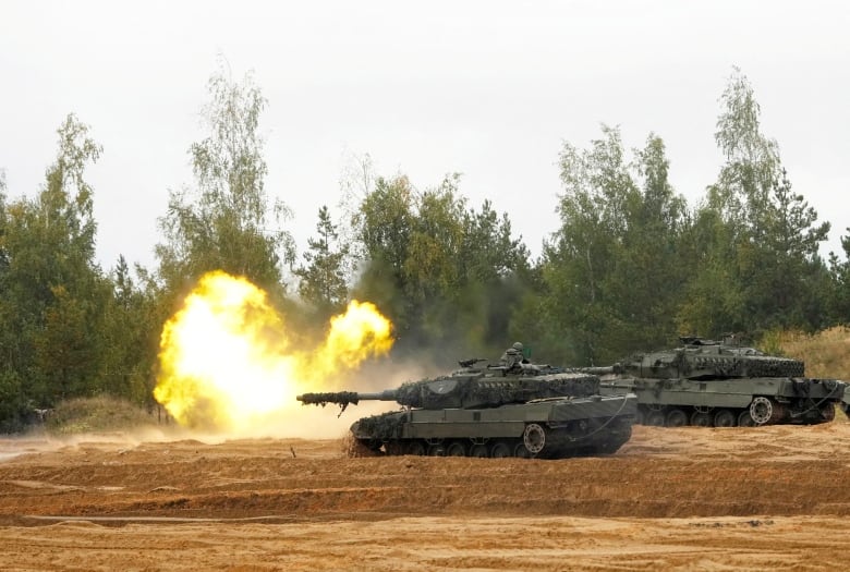 Two tanks after firing (flames are seen)