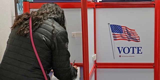 A voter fills out her ballot at the Utah County Election offices in Provo, Utah, on Nov. 4, 2022.