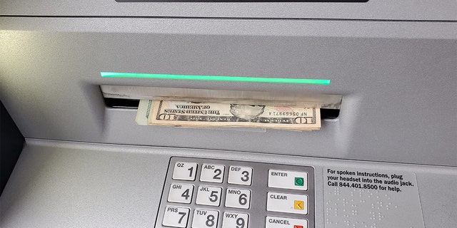 An ATM dispensing cash in Lafayette, California, Dec.22, 2021.