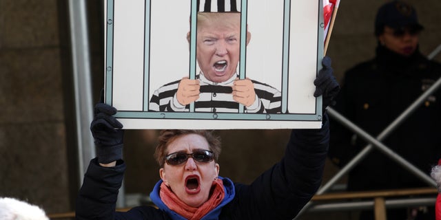 A demonstrator stands outside the Manhattan Criminal Court on March 21, 2023, ahead of an expected grand jury vote on whether to indict former President Donald Trump. 