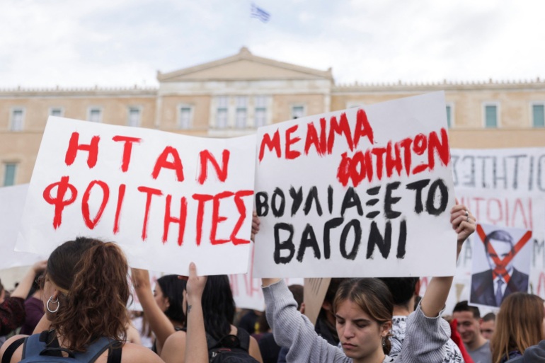 Protesters hold banners during a demonstration in front of the parliament building, following the fatal collision of two trains, in Athens, Greece, March 12, 2023. The banners read "They were students. The wagon sank with students' blood". REUTERS/Louiza Vradi