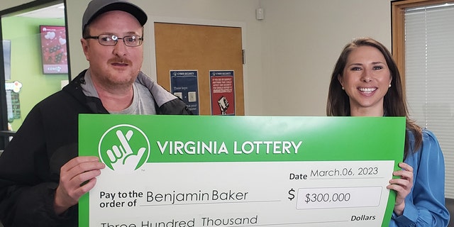 Benjamin Baker, of Covington, Virginia, won $300,000 after matching four number plus the Powerball number on two tickets in the same drawing earlier this month. Baker, left, is pictured with Virginia Lottery Executive Director Kelly T. Gee.