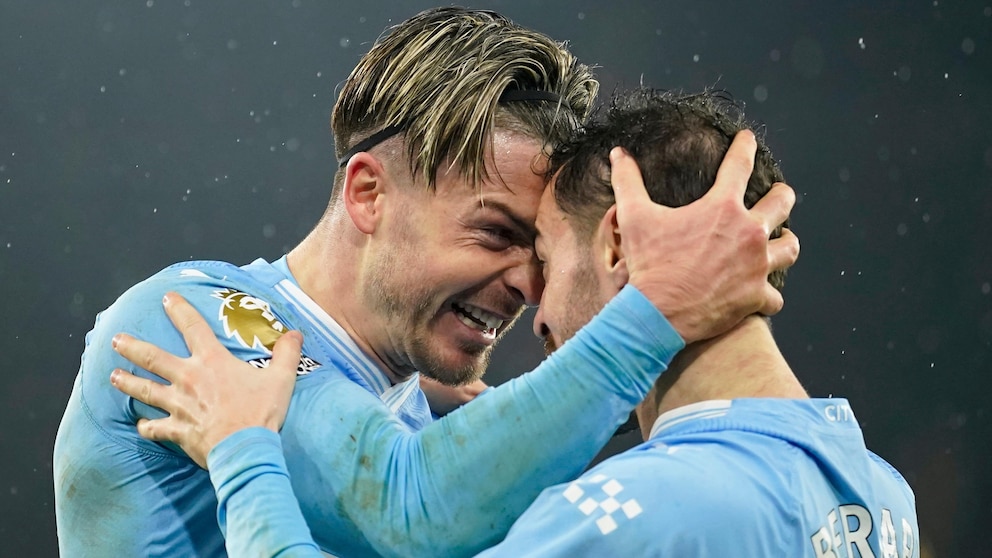 Manchester City's Jack Grealish celebrates with Bernardo Silva, right, after scoring his side's third goal during the English Premier League soccer match between Manchester City and Tottenham Hotspur at Etihad stadium in Manchester, England, Sunday, Dec. 3, 2023. (AP Photo/Dave Thompson)