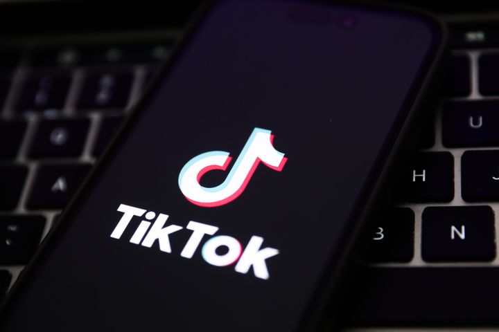 A laptop keyboard and TikTok logo displayed on a phone screen are seen in this illustration photo taken in Krakow, Poland, on Feb. 7, 2024.