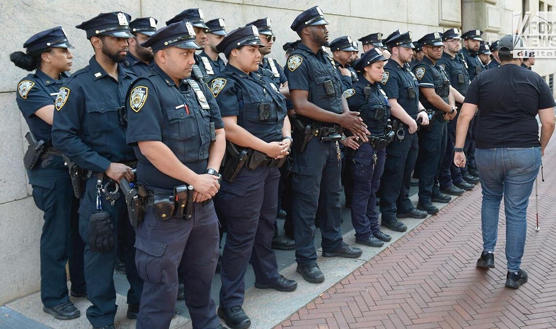 NYPD officers lined against building at Columbia University