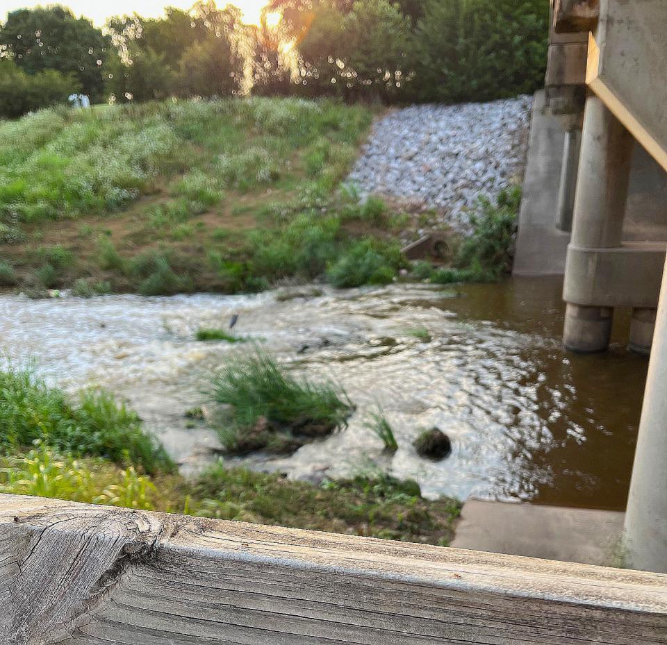 Normally placid Holliday Creek was churning beneath the Midwestern Parkway bridge Sunday.