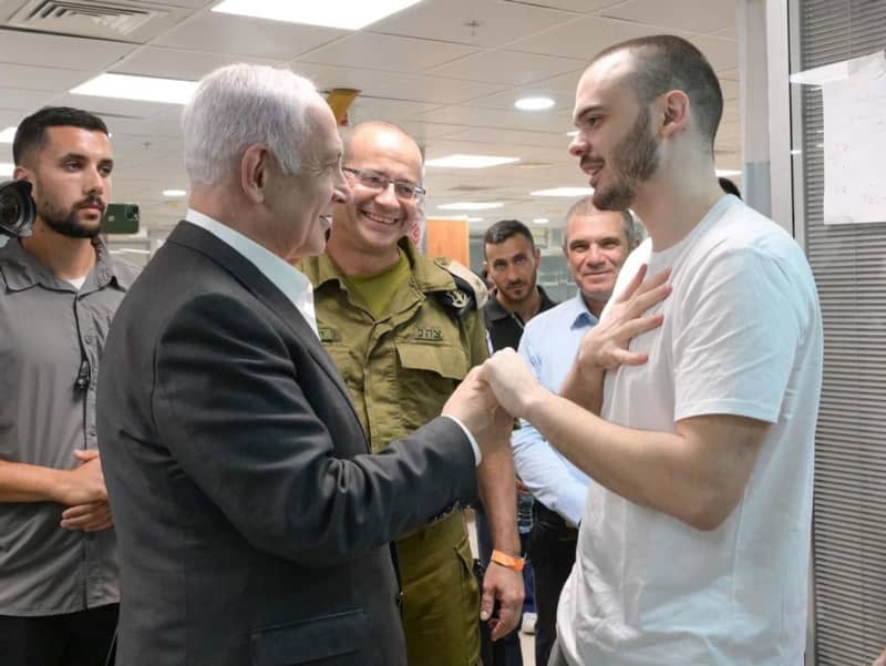 Israeli's Prime Minister Benjamin Netanyahu (L) speaks with the Israeli hostage Andrey Kozlov, 27, at the Sheba Tel-HaShomer Medical Centre, after his rescue by the Israeli army from captivity in the Gaza Strip. -/IDF Spokesperson's unit via GPO/dpa