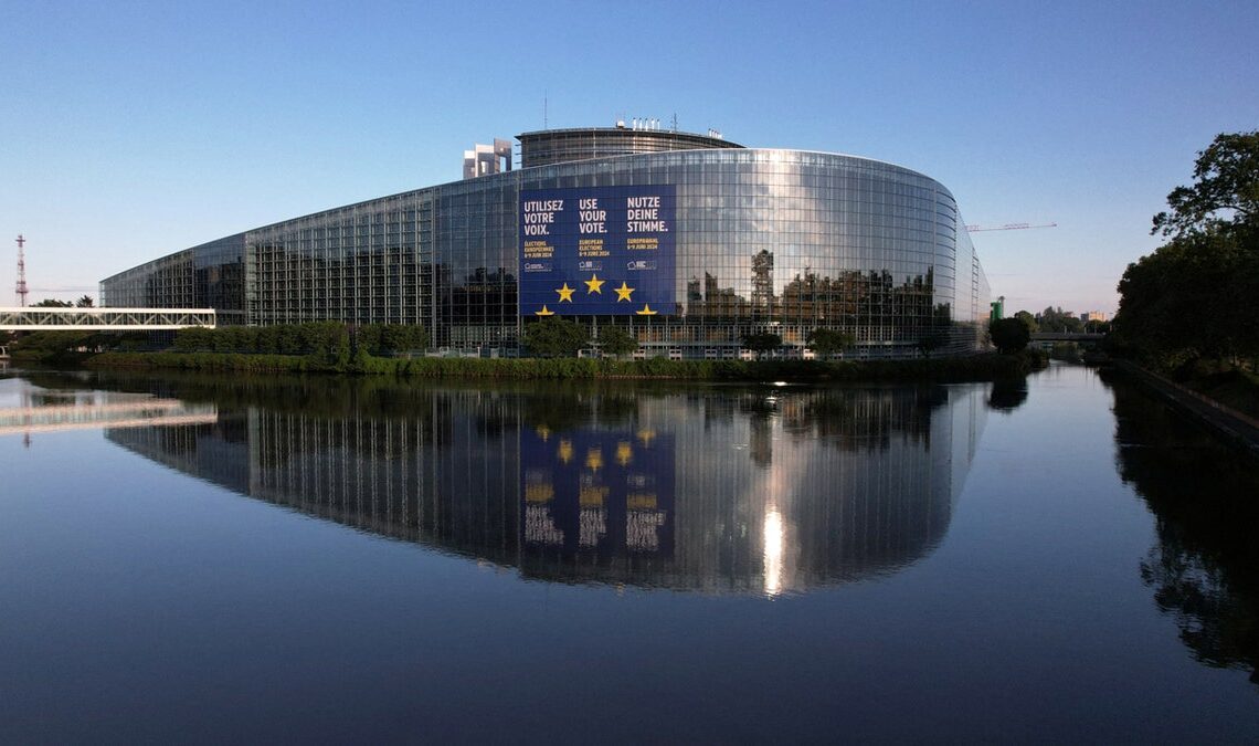 The European Parliament building is reflected on the still water in France.