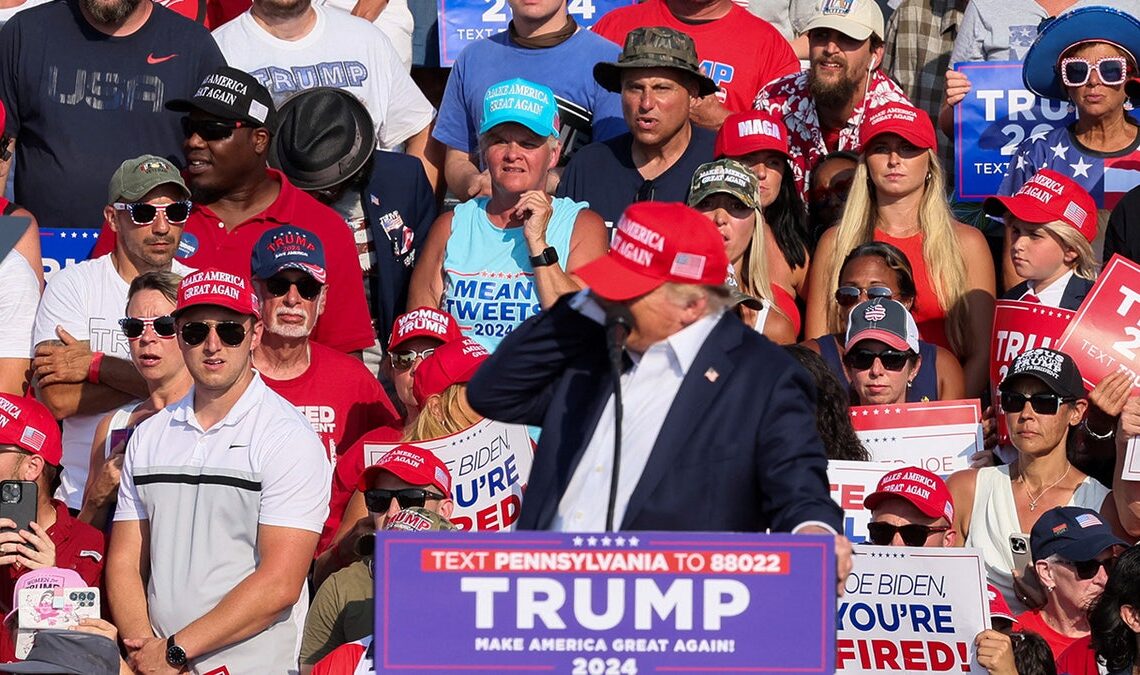 Republican presidential candidate and former U.S. President Donald Trump reacts as multiple shots rang out during a campaign rally