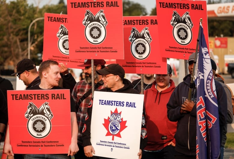 People hold up signs and placards during a strike.