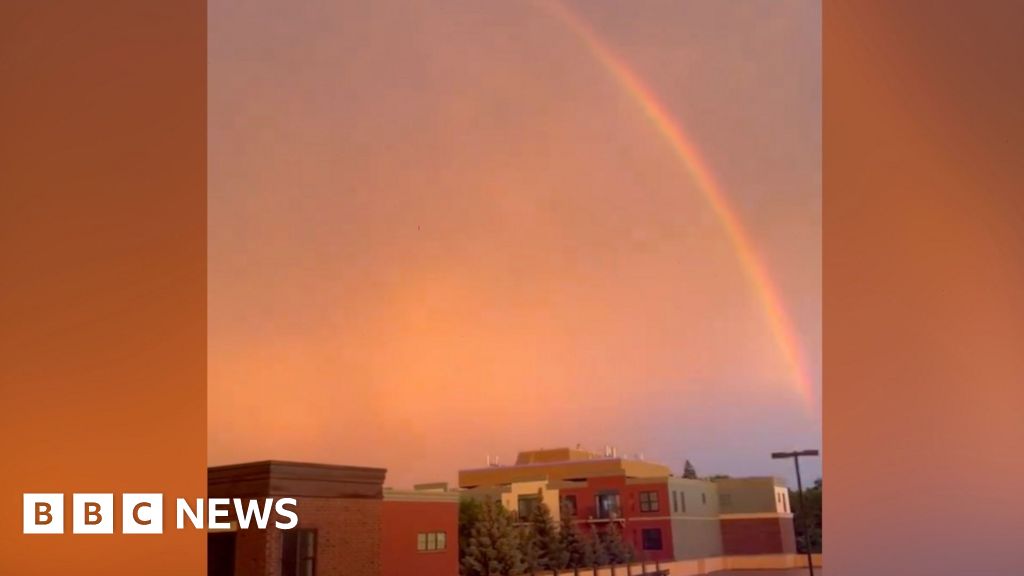 Lightning strikes and a rainbow forms during storm