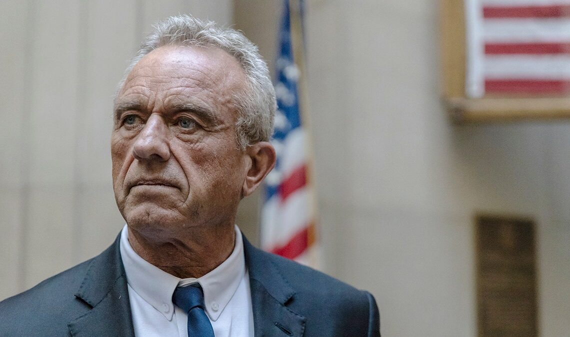 RFK Jr standing in front of an American flag