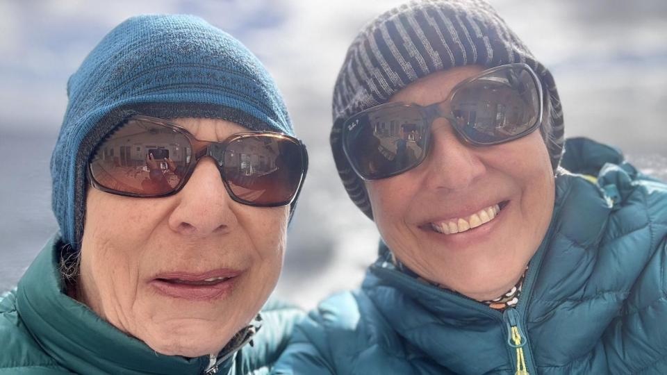 Joan and Jackie wearing sunglasses, woolly hats and jackets