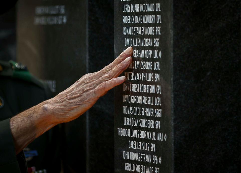 Vietnam veteran Carlos Grant touches the engraved names of fellow service members who died during the war.