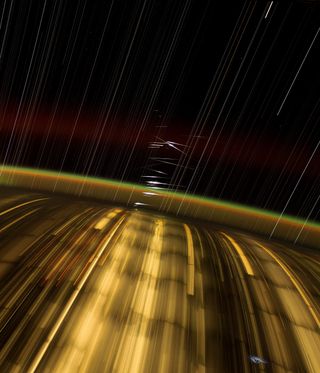 long streaks of light above earth with little white flashes visible in a timelapse photo