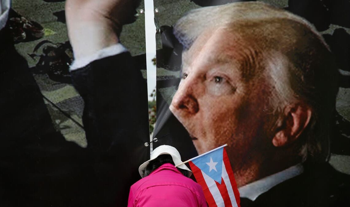 A demonstrator with a Puerto Rican flag attends a rally to protest against Donald Trump on June 18, 2019, in Orlando, Fla.