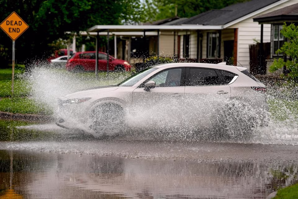 A vehicle drives through water on N Hammond Avenue in Warr Acres, Okla., Wednesday, April 30, 2025.